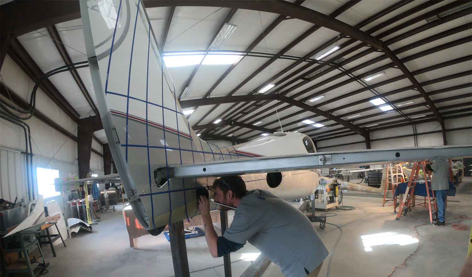 plane mechanic working on body of airplane